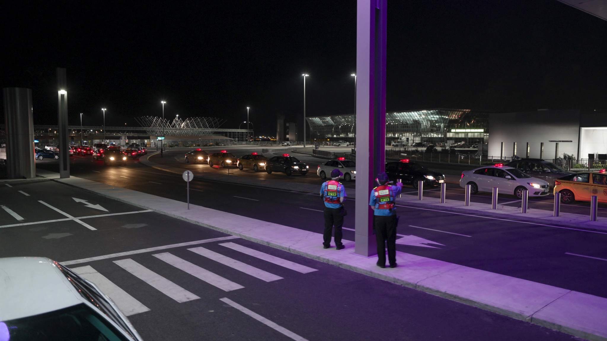 Australian airport terminal kerbside with traffic-control operations and vehicle movement