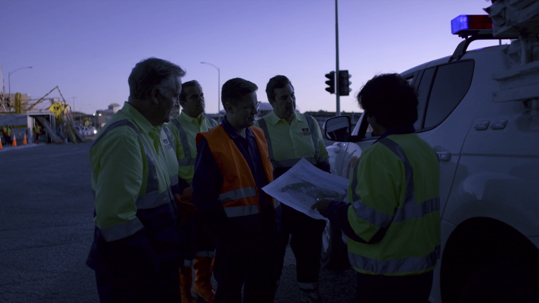 Australian traffic-control team reviewing a works-zone plan during a field handover
